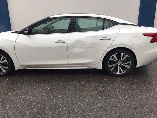 Damaged white coupe before repair
